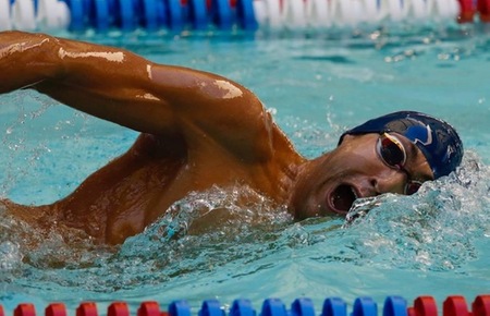 Freshman Charles Caldwell swims freestyle leg of a relay at the NorCal Invitational. Photographer: Guy Mohr