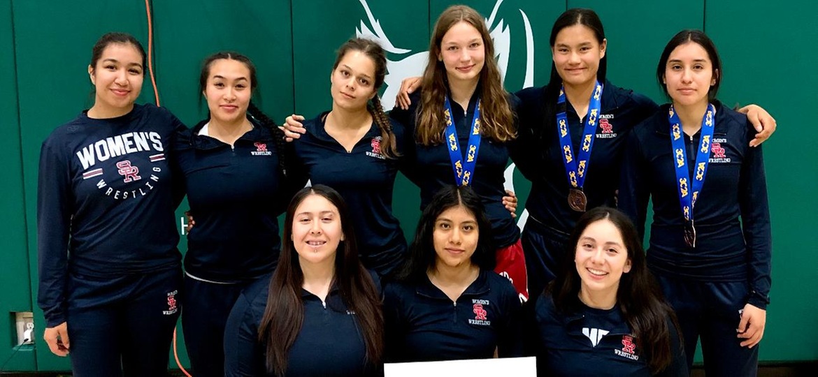 Women's wrestling poses for a team photo following their final match